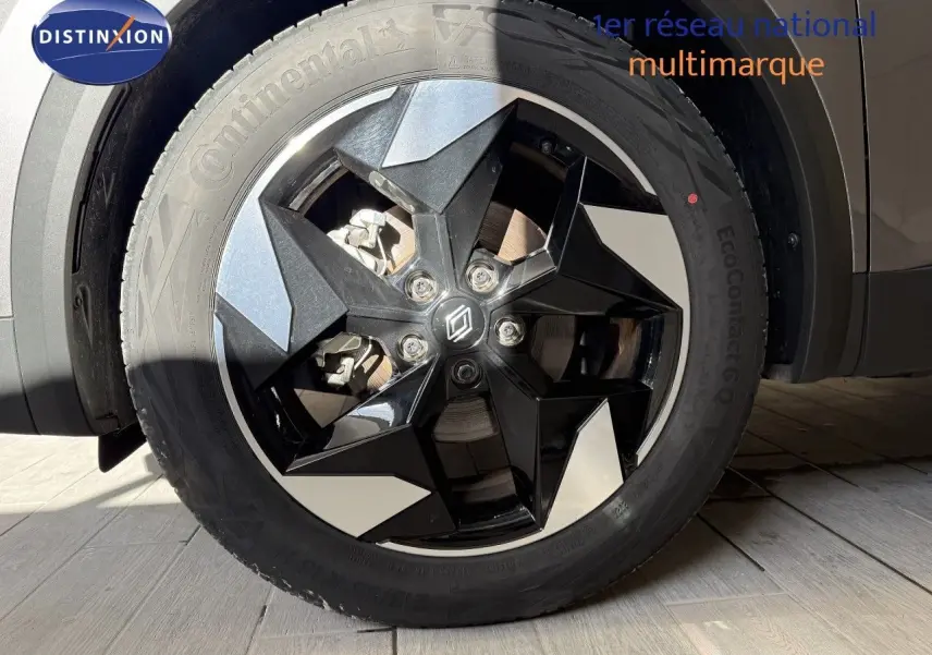 Gros plan sur la roue avant droite du Renault Captur gris Cassiopée Métal avec jante noire et argentée au design géométrique.