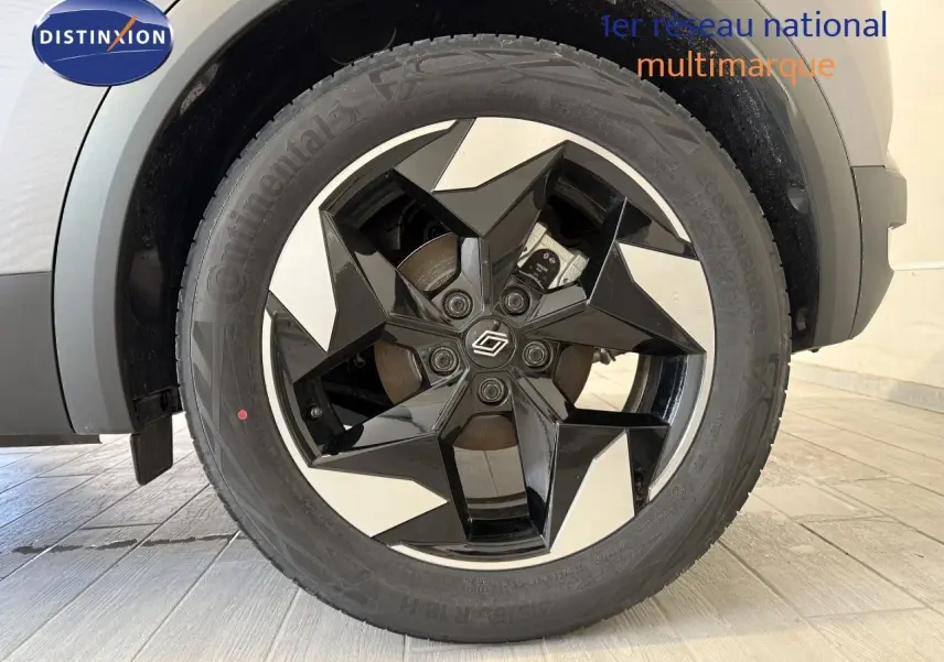 Gros plan sur la roue avant droite du Renault Captur gris Cassiopée, jante alliage noire et argentée à design géométrique.