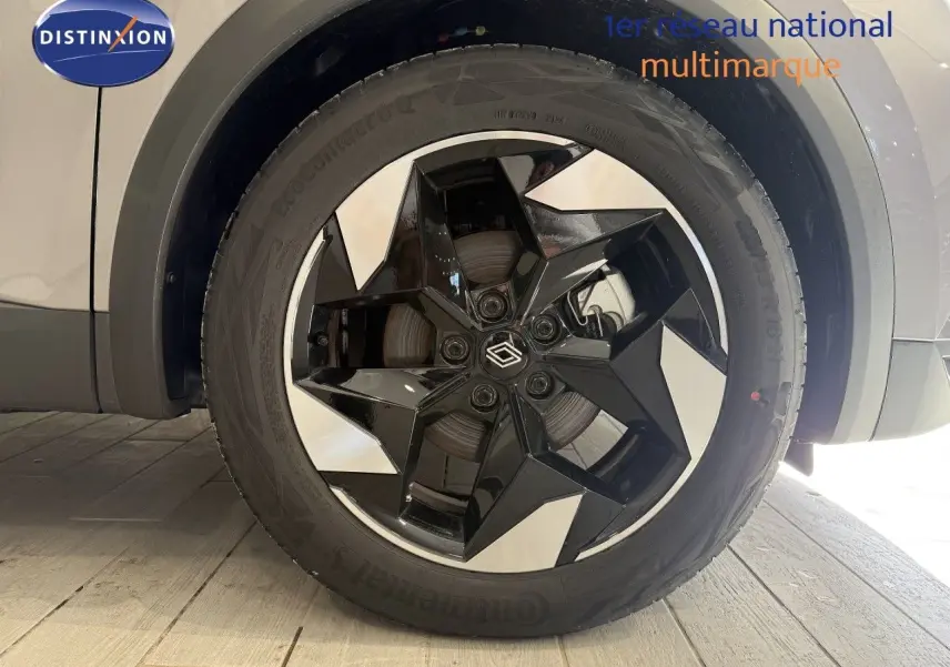 Gros plan sur la roue avant droite du Renault Captur gris Cassiopée Métal avec jante noire et argentée au design géométrique.