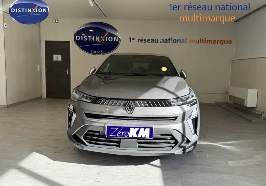 Vue avant d'un Renault Captur gris Cassiopée métal avec toit gris, en intérieur, soulignant sa calandre et ses phares LED.