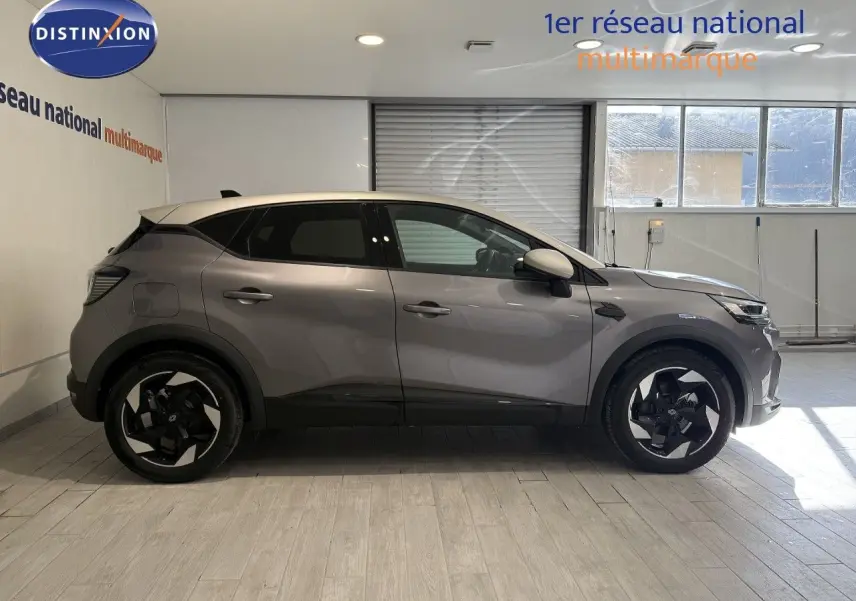 Profil droit du Renault Captur 2025 gris Cassiopée métal avec toit gris, jantes noires et design moderne.