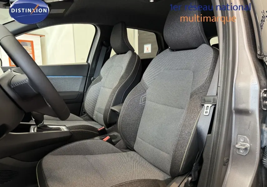 Vue intérieure côté conducteur du Renault Captur 2025 gris Cassiopée, sièges tissu gris avec surpiqûres claires.