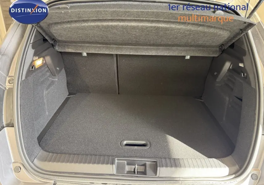 Coffre ouvert du Renault Captur gris Cassiopée métal avec intérieur noir, vue arrière montrant l'espace de chargement.