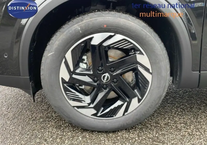 Gros plan sur la jante aluminium noire et argent du côté avant droit du Nissan Qashqai noir 2025.