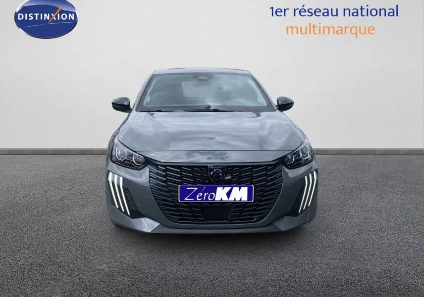 Vue frontale d'une Peugeot 208 Hybrid 110ch gris selenium metal avec feux LED distinctifs allumés.