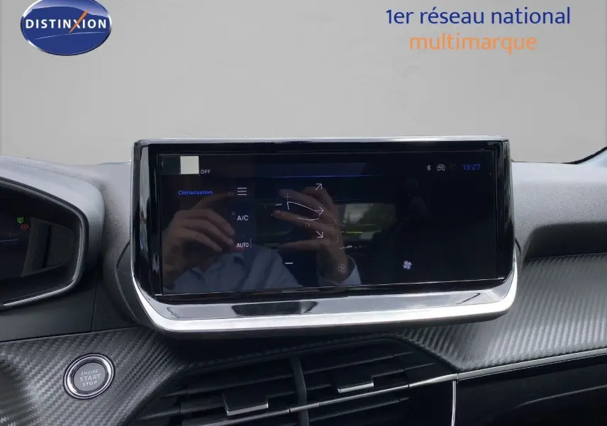 Vue intérieure centrée sur l'écran tactile du tableau de bord de la Peugeot 208 gris selenium hybride 2026.