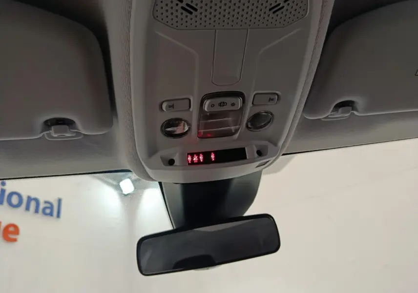 Vue intérieure centrée sur le plafonnier et le rétroviseur intérieur d'une Peugeot 208 2023, éclairage et commandes visibles.