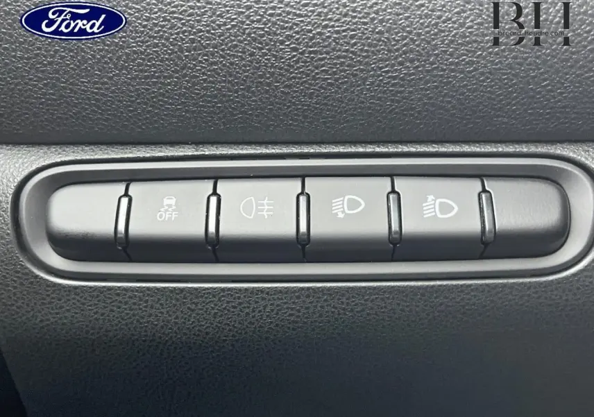 Image montrant un panneau de commandes intérieures noires avec cinq boutons pour fonctions d'éclairage et sécurité.