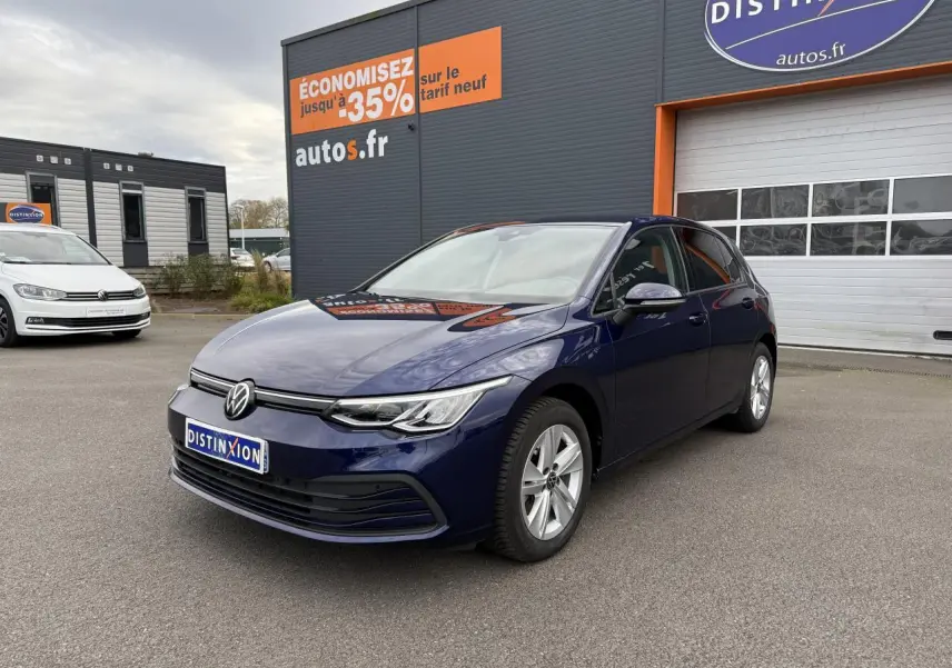 Volkswagen Golf 2.0 TDI 2023 bleu Atlantique métallisé vue 3/4 avant sur parking devant un garage