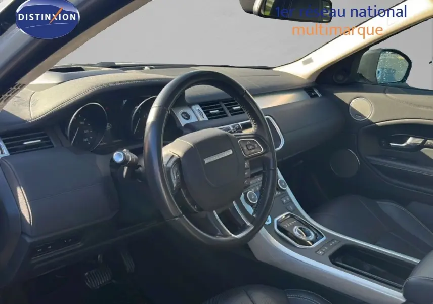 Intérieur noir du Range Rover Evoque 2017 vu côté conducteur, avec tableau de bord moderne et volant multifonction.