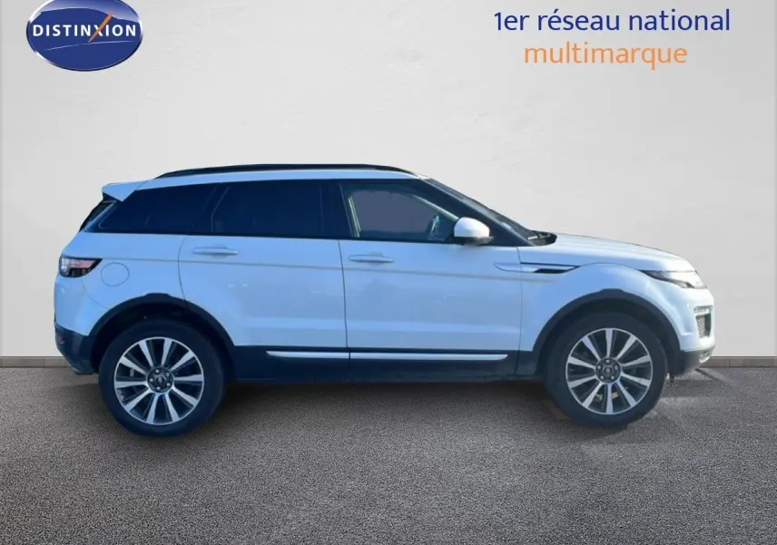 Profil côté gauche d'un Range Rover Evoque blanc 2017 avec toit noir et jantes alliage 19 pouces.