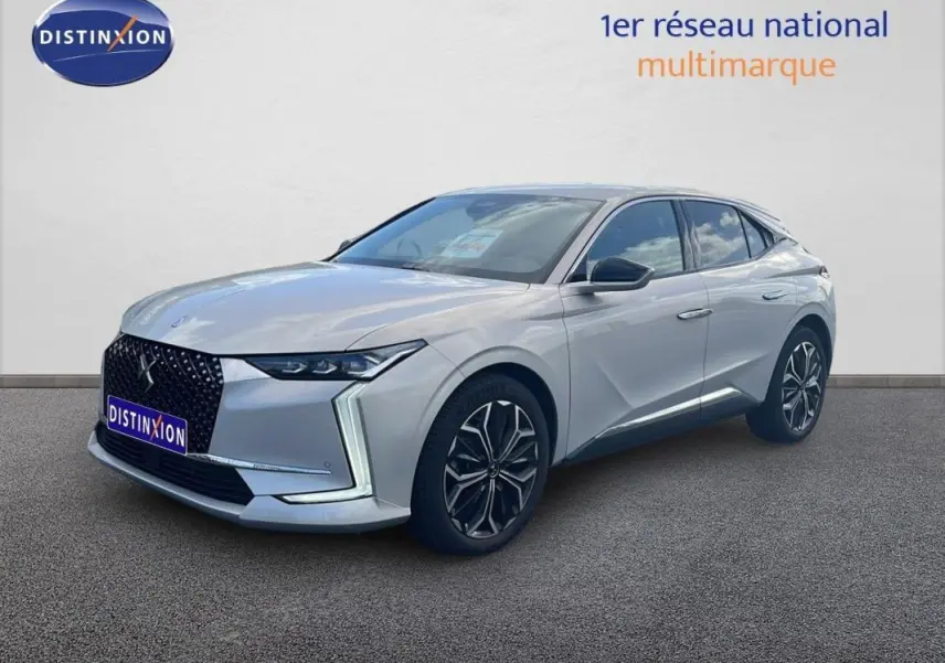 DS4 2024 gris clair vue 3/4 avant droit, calandre noire distinctive et jantes alliage noires et argentées.