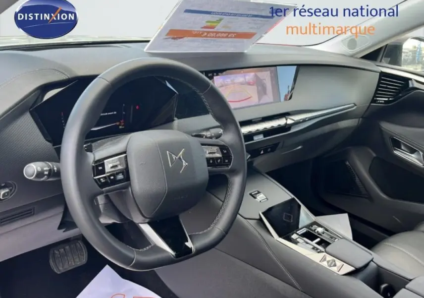 Vue intérieure de profil avant gauche du tableau de bord et volant cuir noir du DS4 2024 avec écran tactile et affichage tête haute.