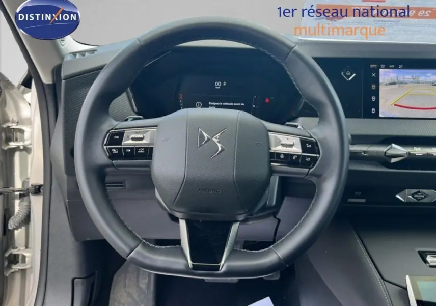 Vue intérieure centrée sur le volant cuir noir de la DS4 2024 avec tableau de bord digital et écran tactile.