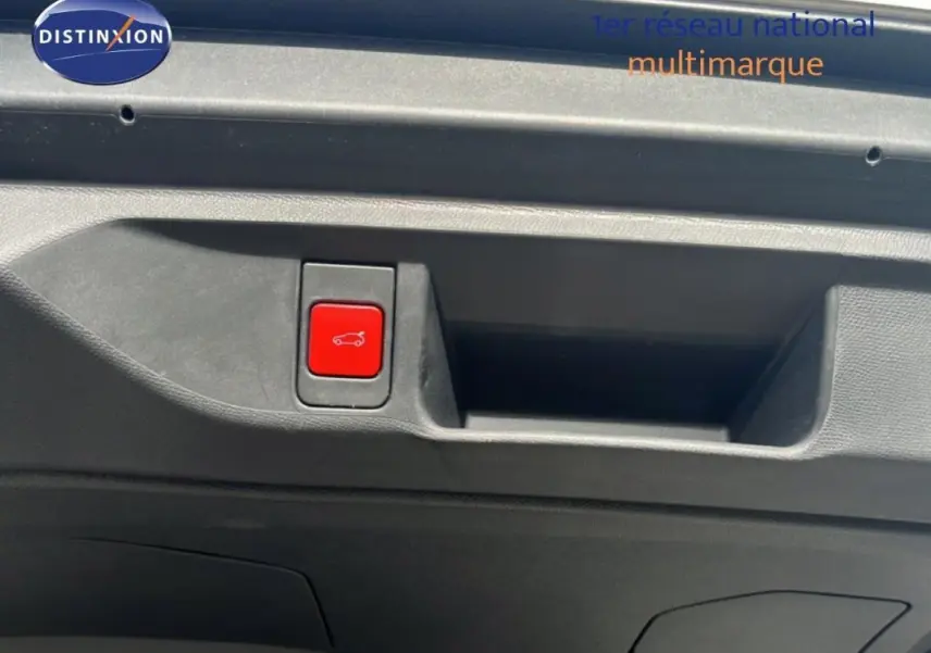 Gros plan sur le bouton rouge d'ouverture du coffre à l'intérieur du hayon d'une DS4 2024 gris foncé.