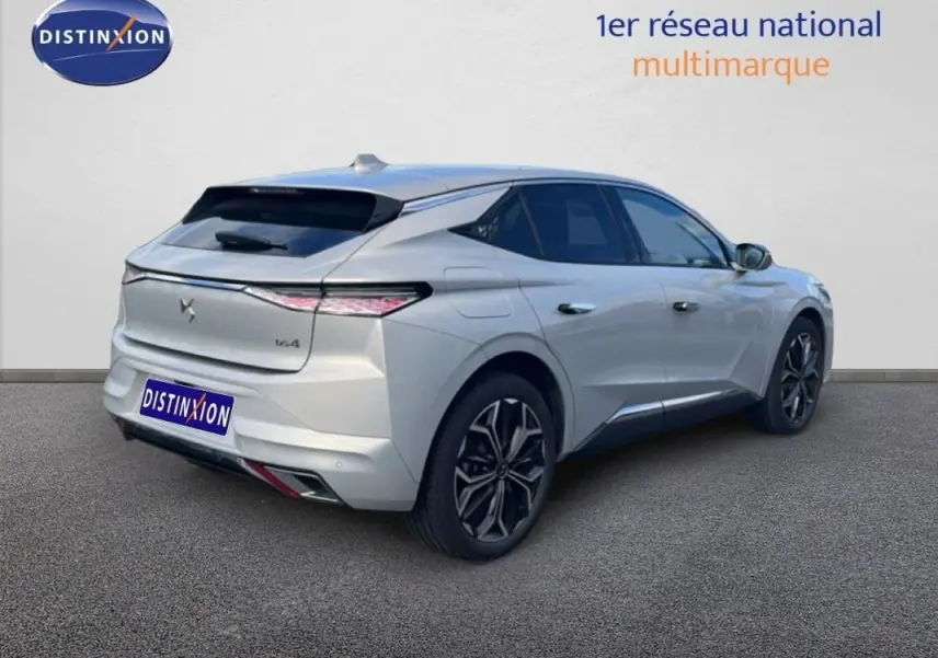 Vue 3/4 arrière droite d'une DS4 blanche avec feux arrière effilés et jantes noires stylisées.