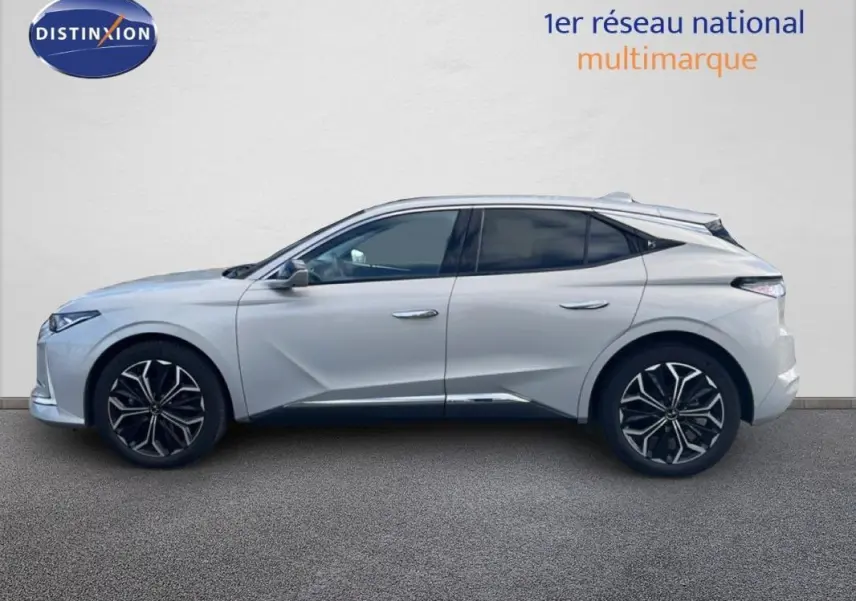 Vue de profil côté gauche d'une DS4 2024 blanche avec jantes noires et détails chromés sous un mur clair.