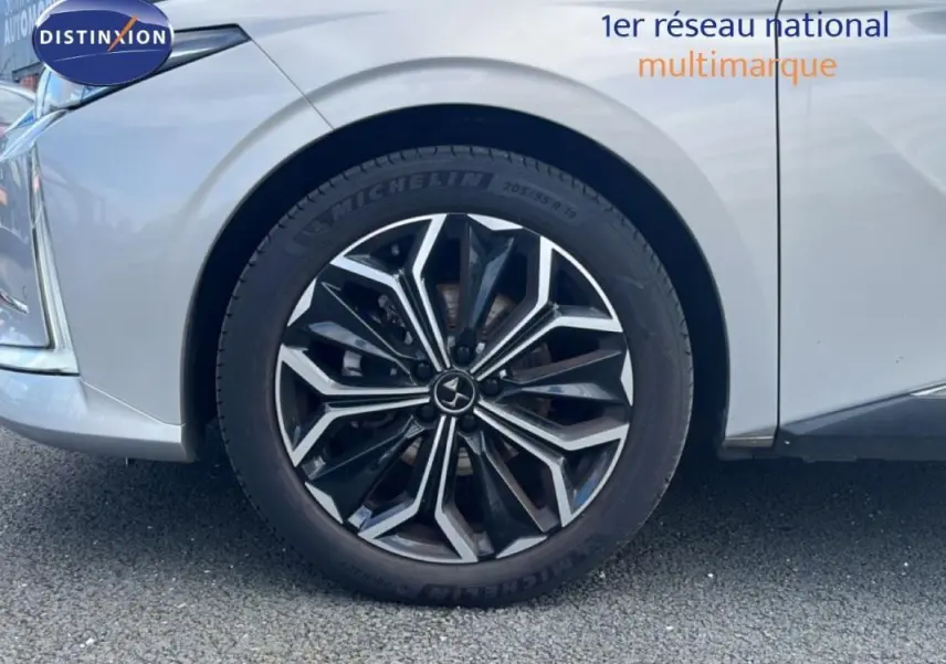 Gros plan sur la roue avant gauche avec jante noire et argentée du DS4 gris clair 2024.