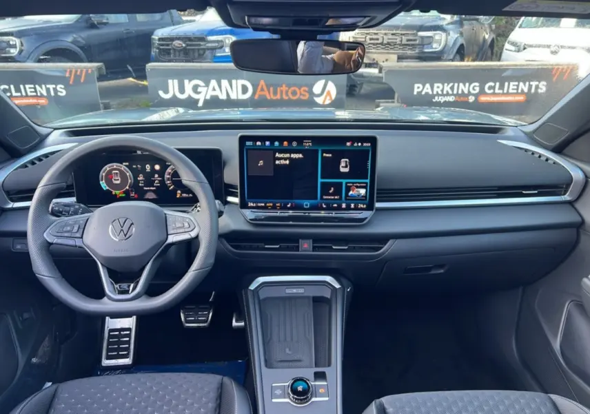 Vue intérieure avant du Volkswagen T-Roc 2026, tableau de bord moderne avec écran tactile central et volant multifonctions cuir.
