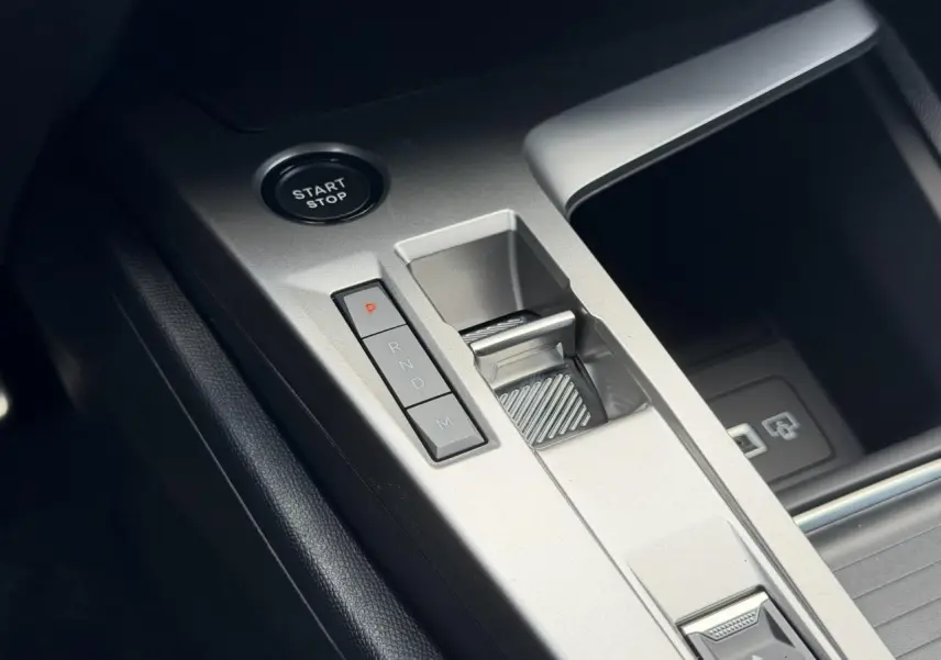 Gros plan sur la console centrale argentée avec bouton Start/Stop et levier de vitesse automatique de la Peugeot 308 Hybrid.
