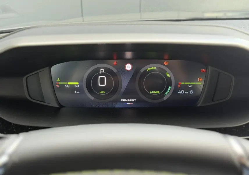 Vue rapprochée du combiné numérique 10'' du Peugeot 308 gris Selenium, affichant la vitesse et l’état hybride.
