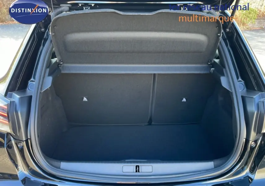 Coffre ouvert en vue arrière d’une Peugeot 208 HYBRID noir perla metal, montrant un espace de chargement vide et propre.
