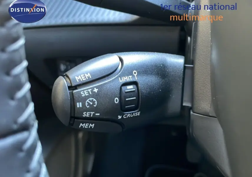 Gros plan sur la commande de régulateur de vitesse de la Peugeot 208 Hybrid 110ch, intérieur noir.