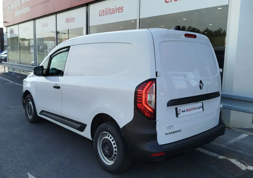 Vue 3/4 arrière droite d’un Renault Kangoo blanc minéral utilitaire avec feux arrière LED et protections noires.