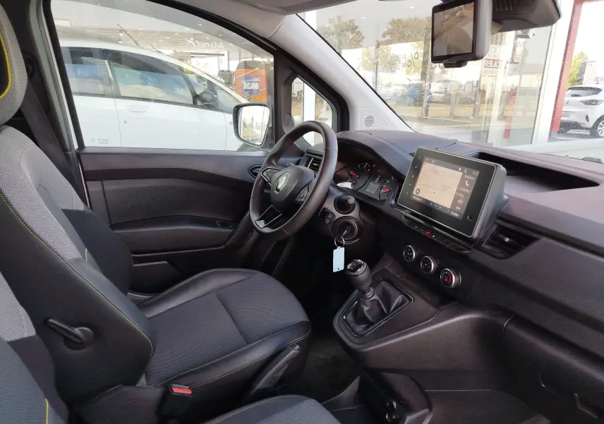 Vue intérieure côté conducteur du Renault Kangoo 2023, tableau de bord avec écran tactile et volant multifonction.