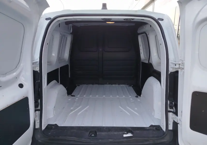 Vue arrière ouverte du Renault Kangoo blanc minéral 2023, montrant l'espace de chargement vide et les portes battantes.