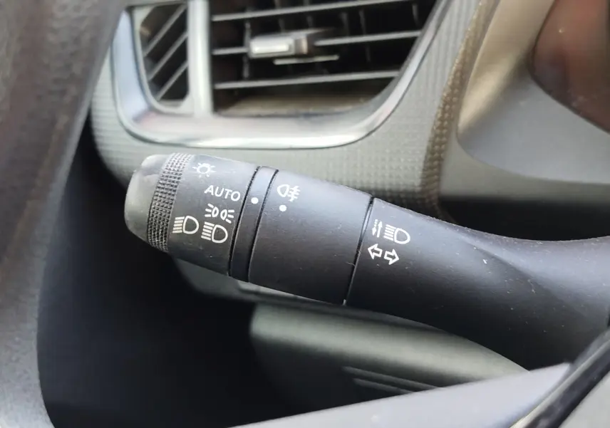 Gros plan sur la manette de commande des feux et clignotants du Renault Kangoo 2023, intérieur noir et gris.
