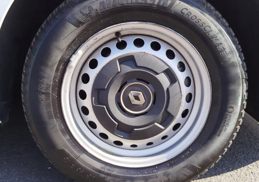Gros plan sur la roue avant gauche blanche d’un Renault Kangoo 2023 avec jante acier et pneu Michelin CrossClimate 2.