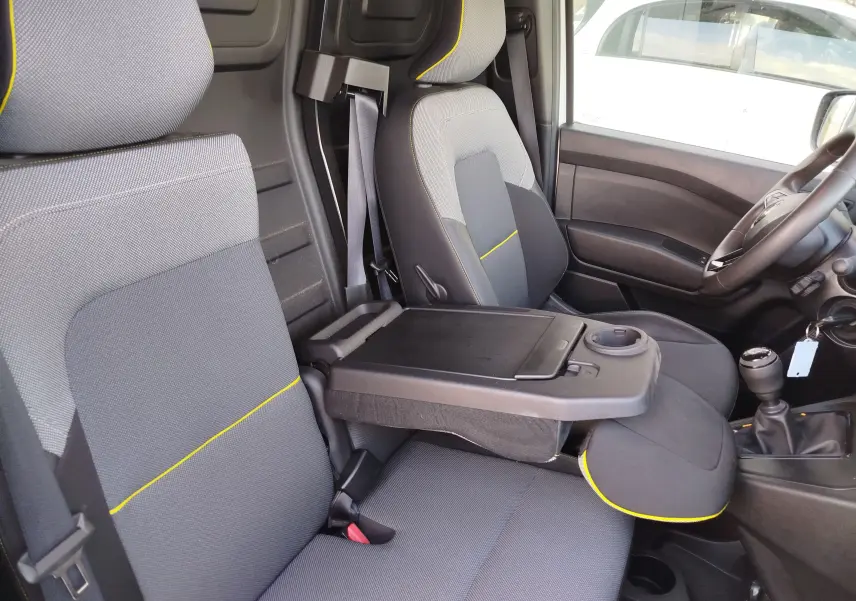 Vue intérieure côté gauche du Renault Kangoo 2023, sièges gris avec surpiqûres jaunes et console centrale rabattable.