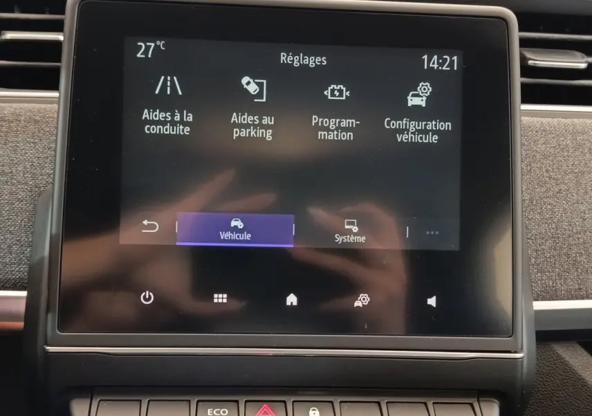 Écran tactile central de la Renault ZOE Intens blanc, affichant les réglages d’aides à la conduite et au parking.