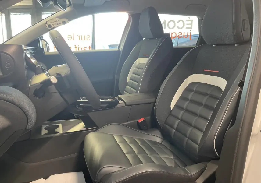 Vue intérieure côté conducteur du Citroën C5 Aircross 2026, sièges noirs avec inserts gris clair et détails rouges.