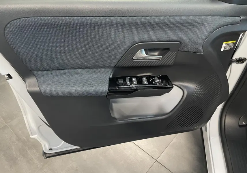 Vue rapprochée de la porte avant gauche blanche du Citroën C5 Aircross 2026 avec commandes électriques et poignée noire.