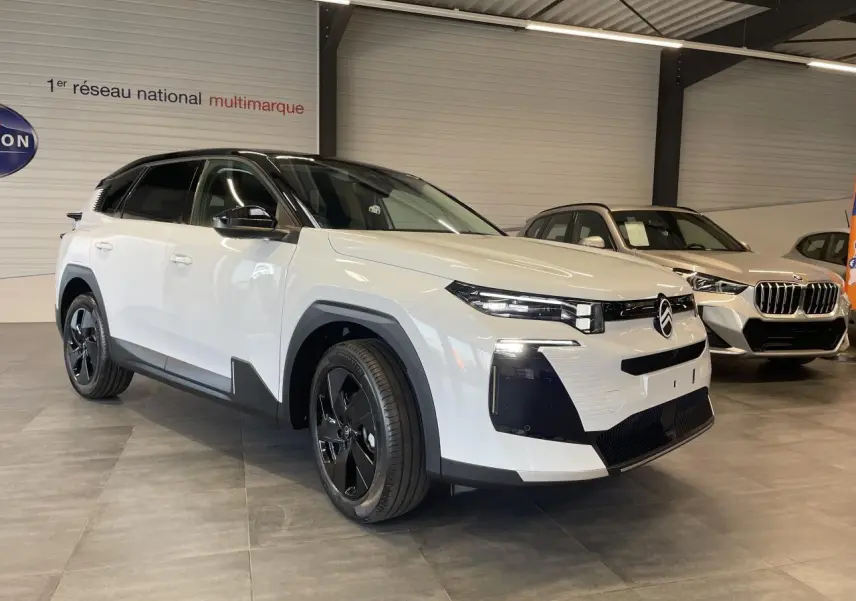 Citroën C5 Aircross blanc Okenite avec toit noir, vue 3/4 avant droit en intérieur showroom.