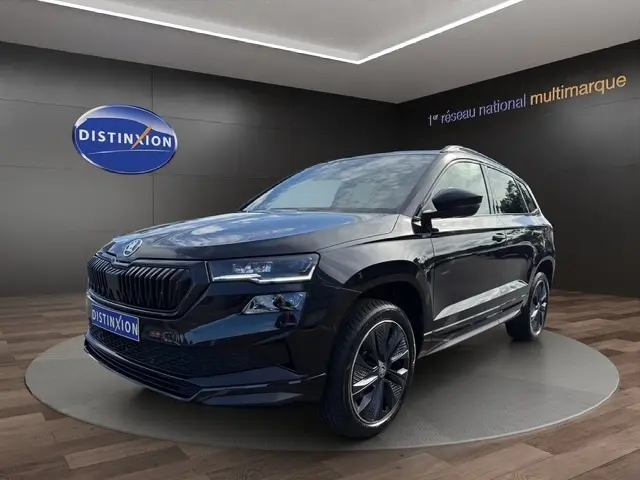 Skoda Karoq noir vue 3/4 avant droit, avec calandre noire et jantes alliage distinctives.