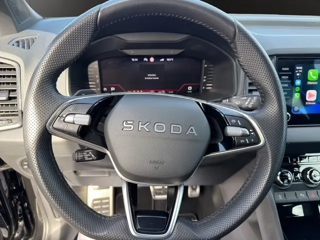 Vue rapprochée du volant cuir perforé noir du Skoda Karoq 2025 avec commandes multifonctions et tableau de bord numérique.