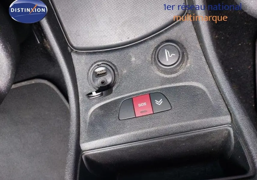 Gros plan sur la console centrale d'une Citroën C4 Picasso gris alu, montrant les boutons SOS et de réglage siège.