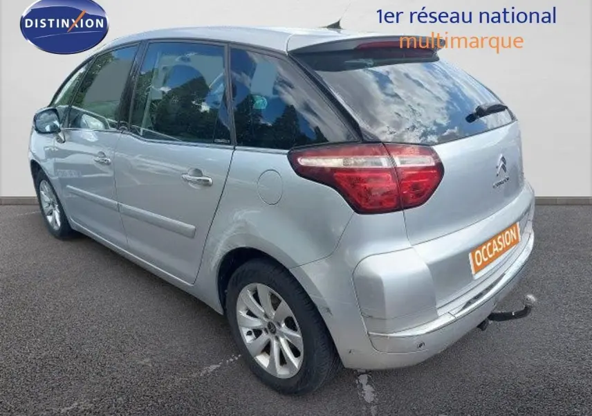 Vue 3/4 arrière droite d'une Citroën C4 Picasso gris alu métal avec attelage et feux arrière LED.