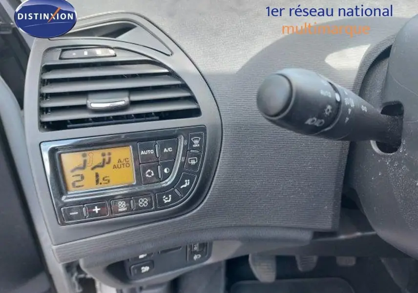 Détail du tableau de bord côté gauche avec commandes de climatisation numérique d'une Citroën C4 Picasso gris alu 2013.