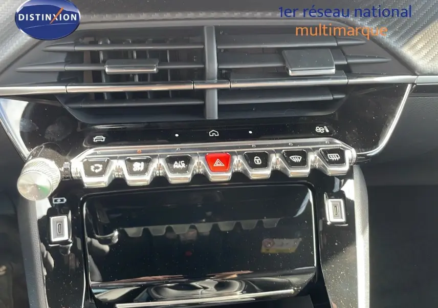Vue rapprochée du tableau de bord noir brillant du Peugeot 2008 2025 avec commandes tactiles et aérateurs horizontaux.
