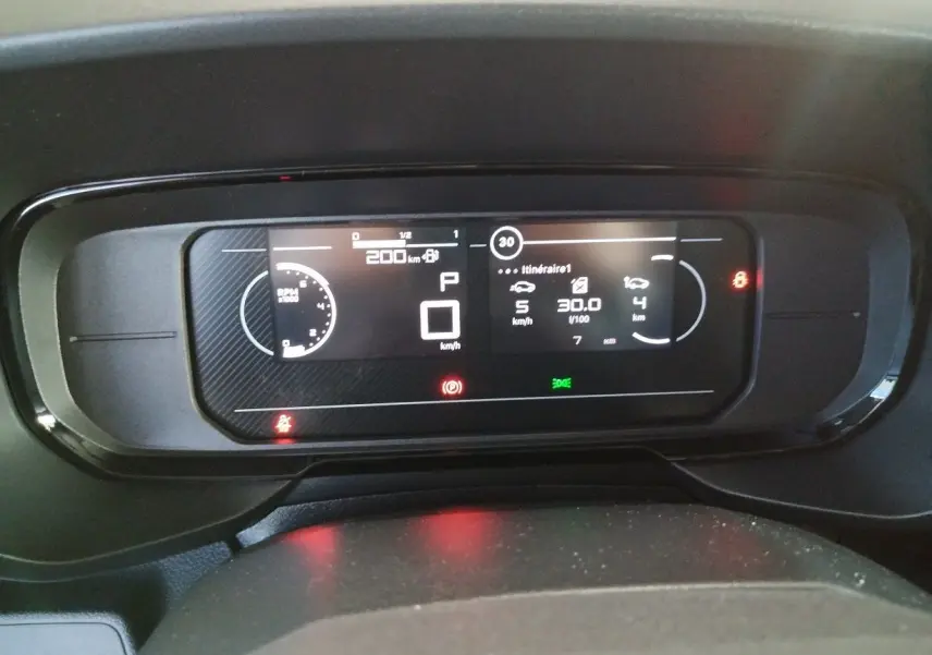 Tableau de bord numérique du Citroën Berlingo 2025 affichant vitesse, consommation et alertes en vue frontale rapprochée.