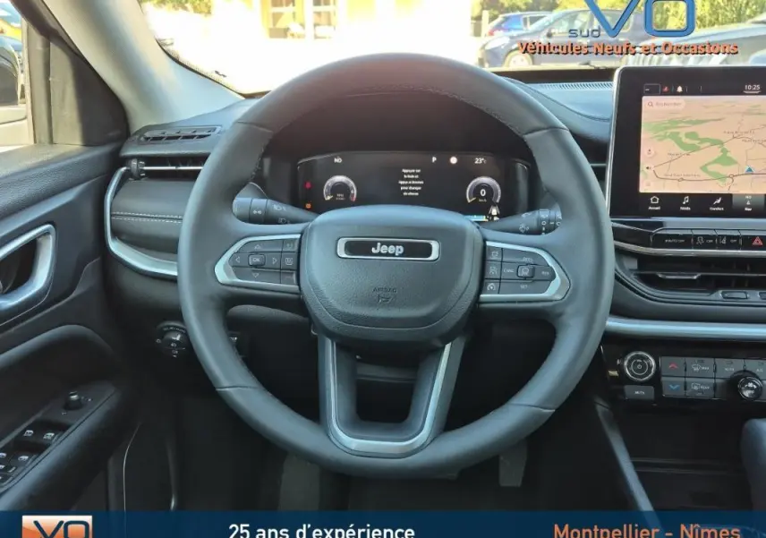 Vue intérieure centrée sur le volant noir du Jeep Compass 2023 avec tableau de bord numérique et écran tactile.
