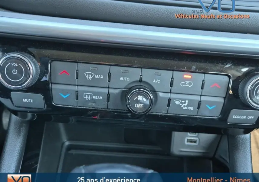 Vue rapprochée du tableau de bord noir du Jeep Compass 2023 montrant les commandes de climatisation et multimédia.