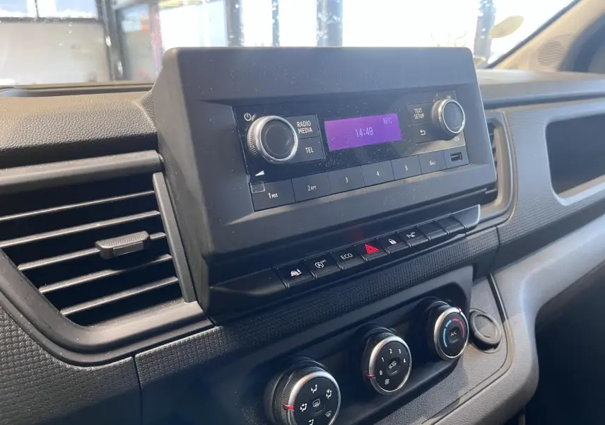 Tableau de bord du Renault Trafic Fourgon 2023, vue rapprochée de la console centrale avec radio et commandes climatisation.