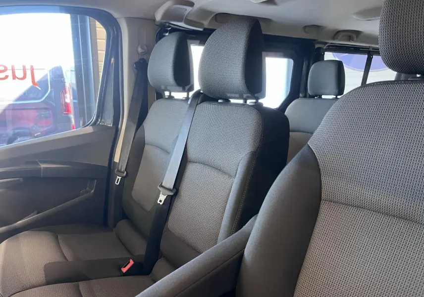 Vue intérieure côté gauche sur les sièges avant gris foncé du Renault Trafic Combi 9 places, tissu Kompo Black.