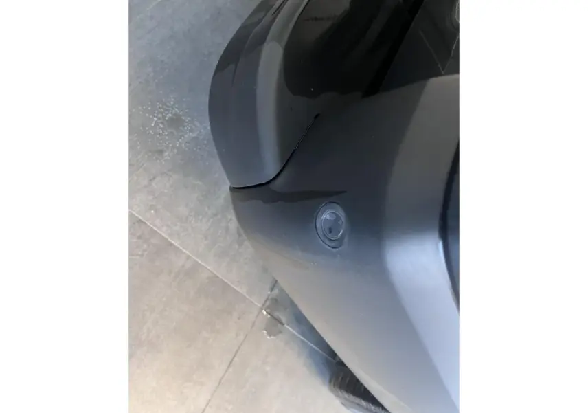 Détail du bouclier avant gris foncé du Renault Trafic Fourgon vu de dessus, avec capteur de stationnement visible.