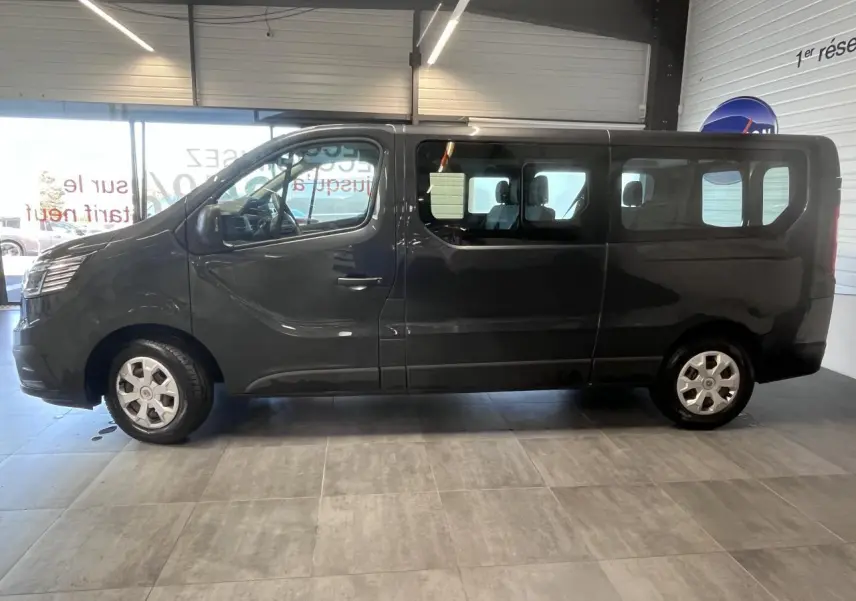 Vue de profil côté gauche du Renault Trafic Fourgon gris foncé, avec vitres latérales teintées et roues 16 pouces.